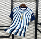 Blue and white striped shirt with a logo on a hanger against a wire mesh background