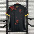 Black sports jersey with red patterns and 'CR7' branding on a hanger against a grid background.